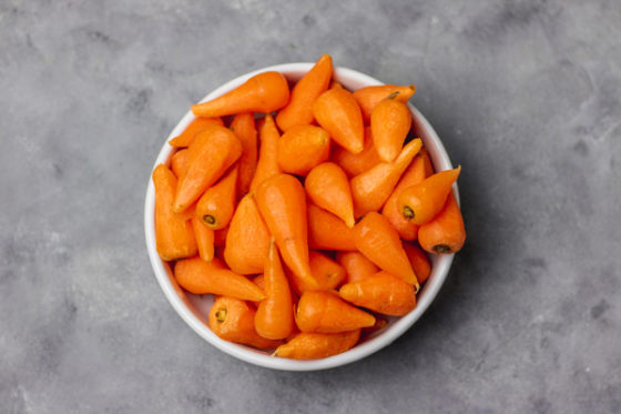 peeled and cleaned carrots in a white bowl.