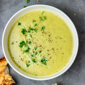 a bowl of broccoli soup and crusty garlic bread.