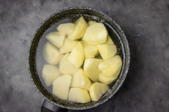 potatoes in a pan coveved with cold water about to be boiled.