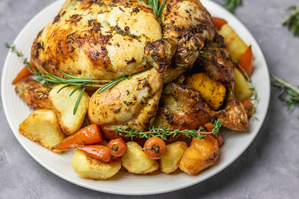 Christmas roast chicken with glazed carrots, roasted potatoes and fresh herbs.