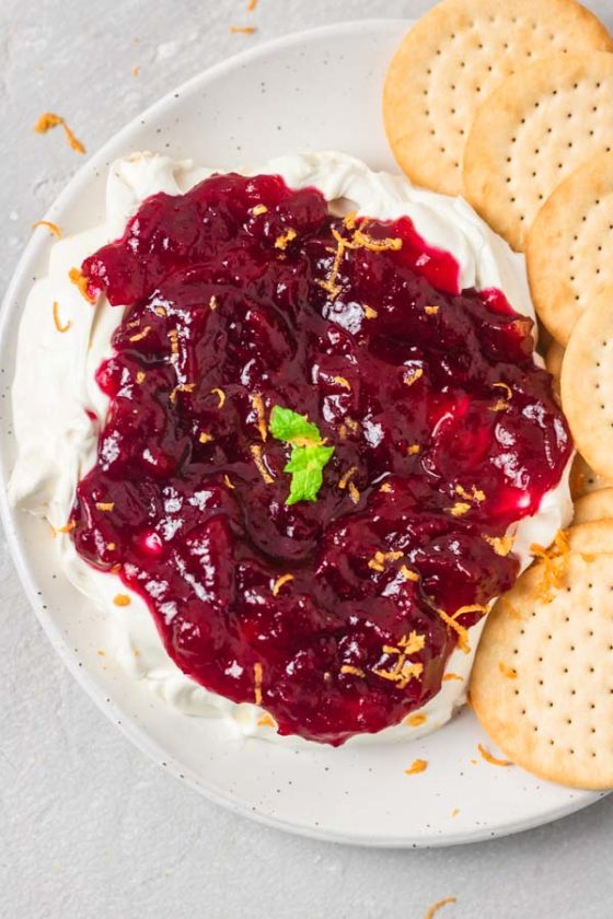 cranberry cream cheese dip and crackers in a plate.