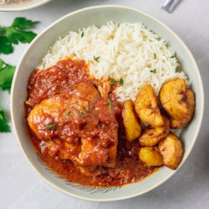 instant pot chicken cacciatore served with rice and fried plantain in a bowl.