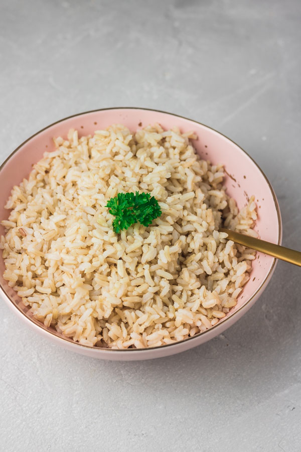 a binl bowl of instant pot brown rice garnished with parsley.