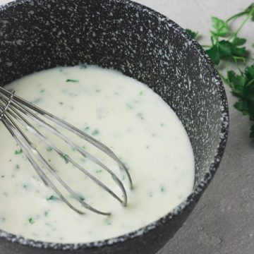 parsley sauce and a whisk in a black pan.
