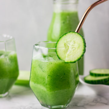 a glass of cucumber juice with golden straw.