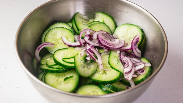 a stainless bowl of cucumber salad.
