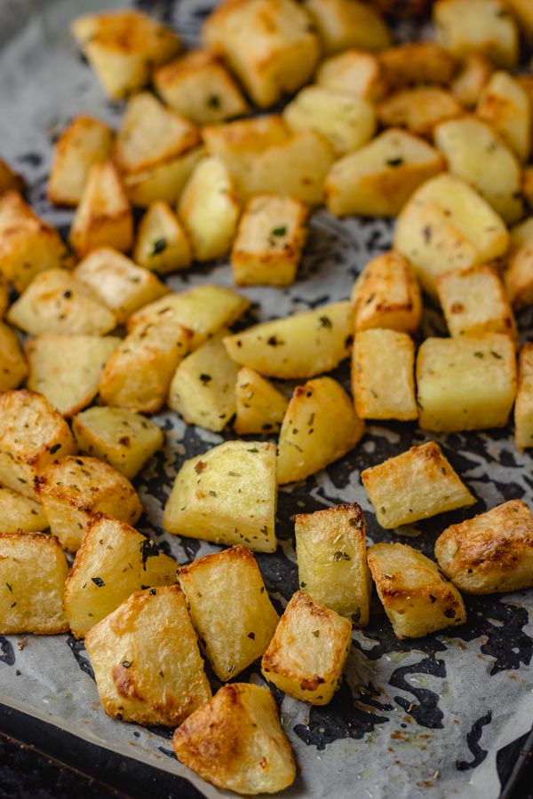 freshly baked cubed potatoes on a tray.