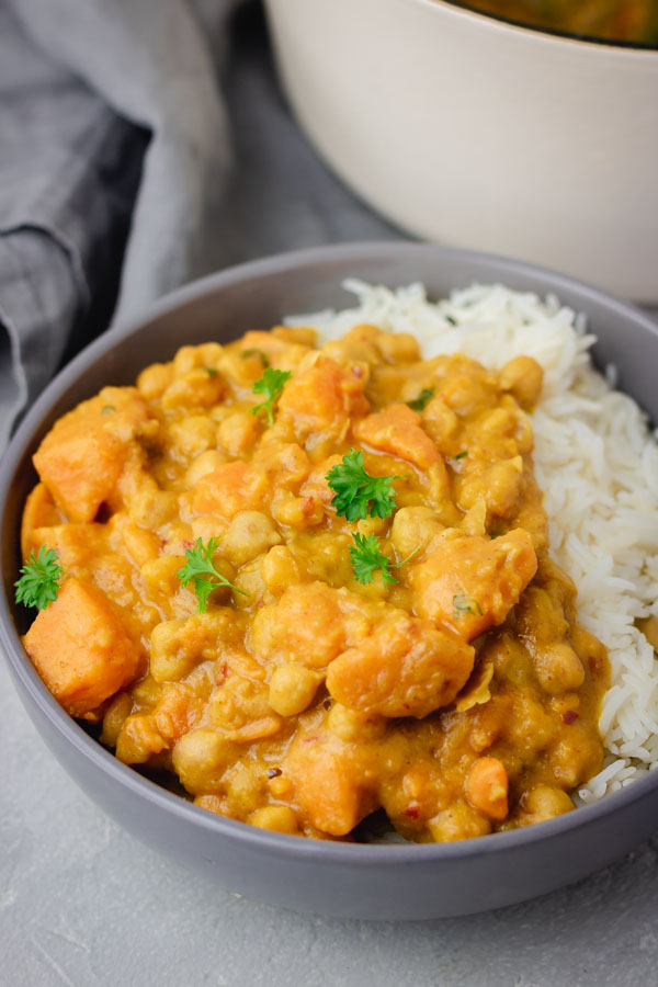a bowl of sweet potato and chickpea curry served with basmati rice.