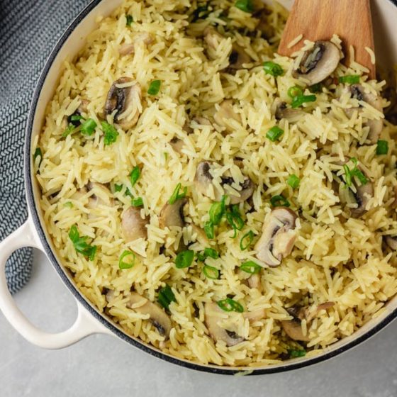 a pot of mushroom rice pilaf garnised with chopped green onions.