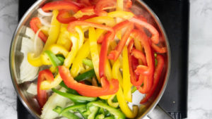 mixed bell peppers in a skillet about to be sauteed