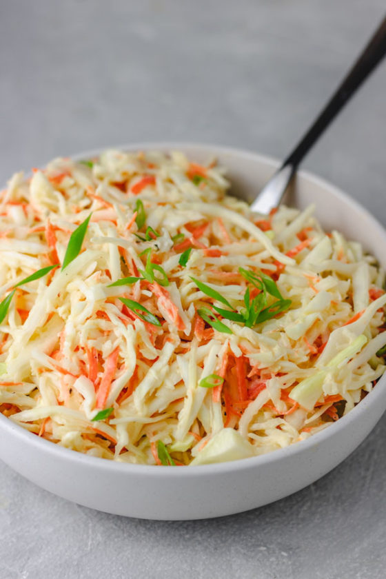 a bowl of cabbage garnished with chopped green onions.