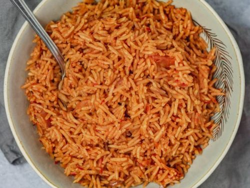 a plate of jollof rice placed on a grey napkin.