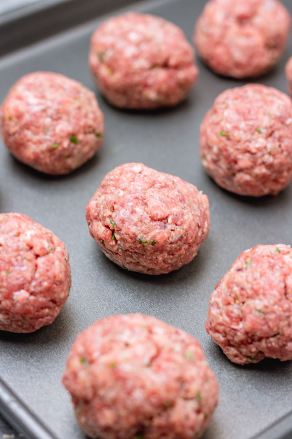 raw meatballs on a baking tray.