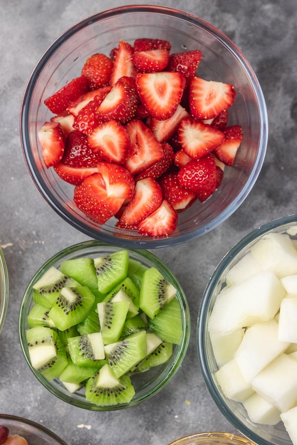 a bowl of chopped strawberries, melon and kiwi.