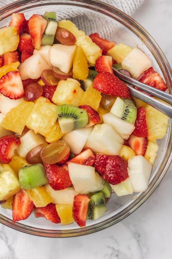 a bowl of fruit with spoon.