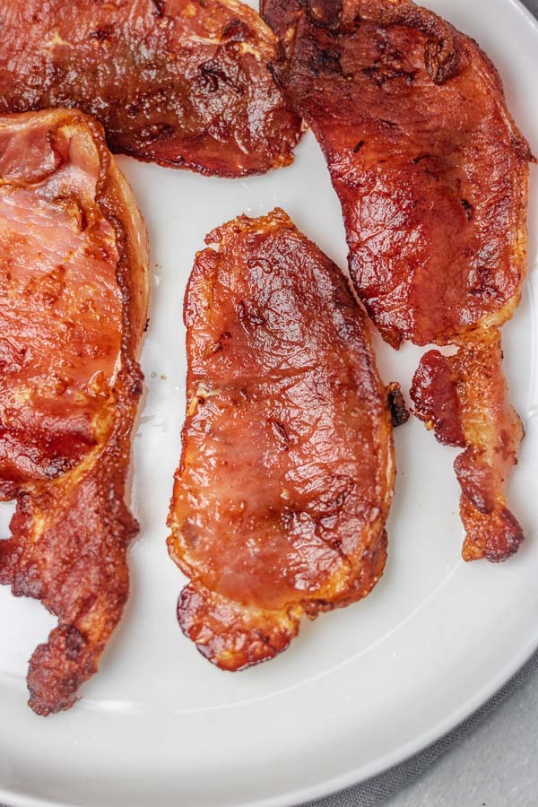 a plate of cooked bacon rashers.