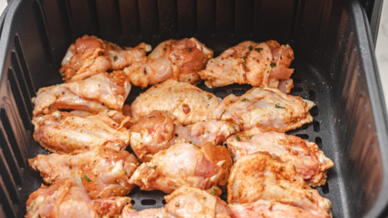chicken wings in an air fryer basket.