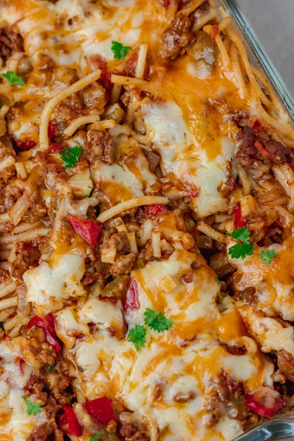  baked spaghetti topped with cheese divided in a baking dish.