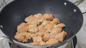 chicken sauteing in a wok.