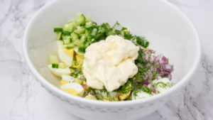 chopped onions, cucumber and mayonnaise in a bowl