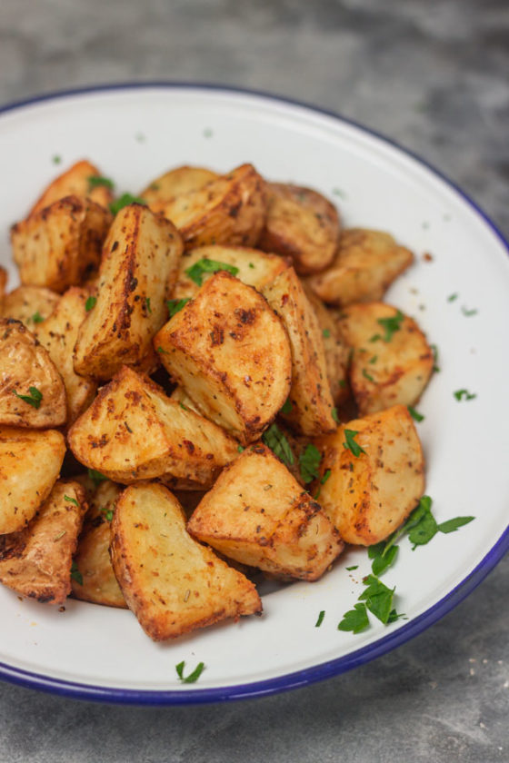 a plate of potatoes garnished with chopped parsley 