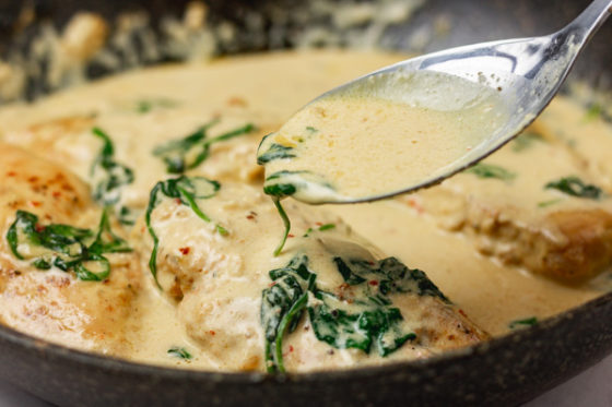 a spoon of creamy sauce and spinach.