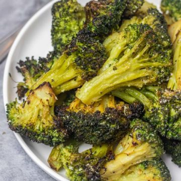 a plate of roasted broccoli florets.
