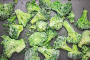 frozen broccoli florets in a baking tray.