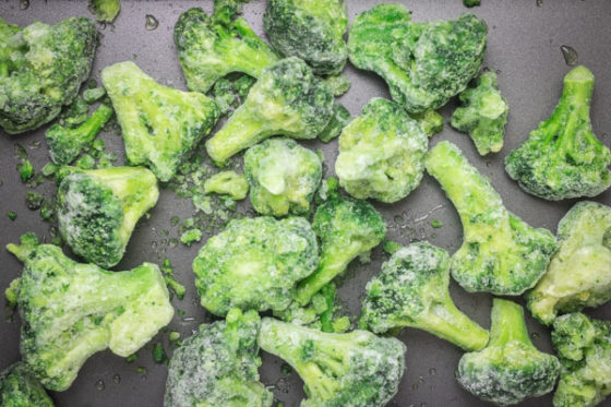 frozen broccoli florets on a tray.