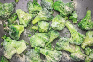 frozen broccoli florets in a tray.