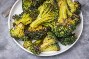 roasted broccoli florets in a white bowl.