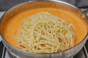 spaghetti in sauce in a pan.