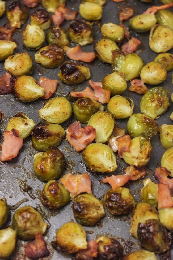 freshly roasted bacon and brussels sprouts in a baking tray.
