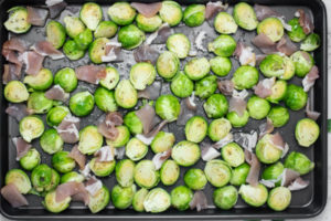 brussels sprouts and bacon arranged on a baking tray.