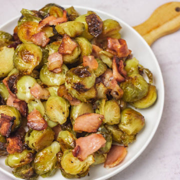 a plate of cooked brussels sprouts and bacon.