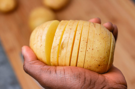 a hand holding a potato.