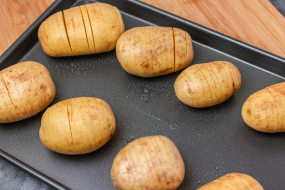 raw potatoes on a baking tray.