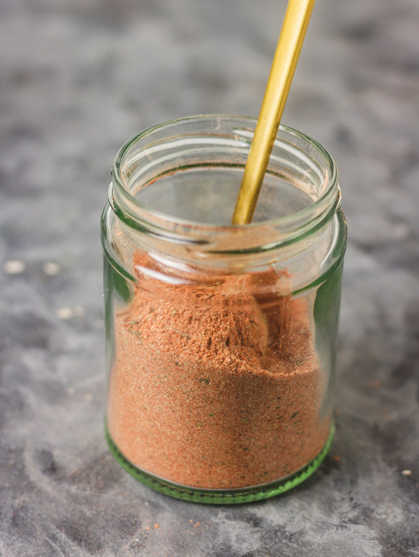 a jar of spice with a spoon in it.