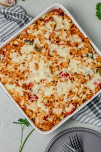 baked pasta in a baking pan placed on a kitchen towel.