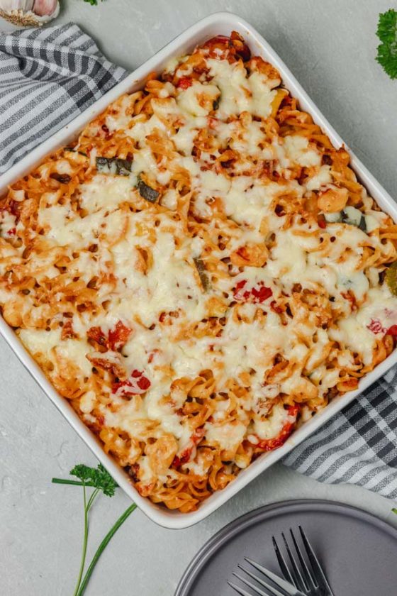 baked pasta in a baking dish placed on a white and gray napkin.
