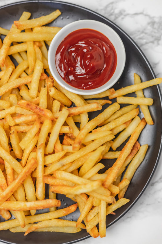 A plate of fries and ketchup.