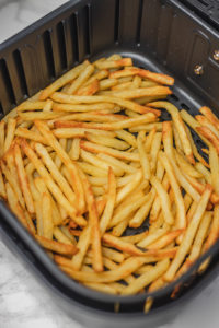 french fries in air fryer basket.