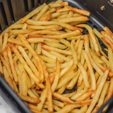 french fries in air fryer basket.