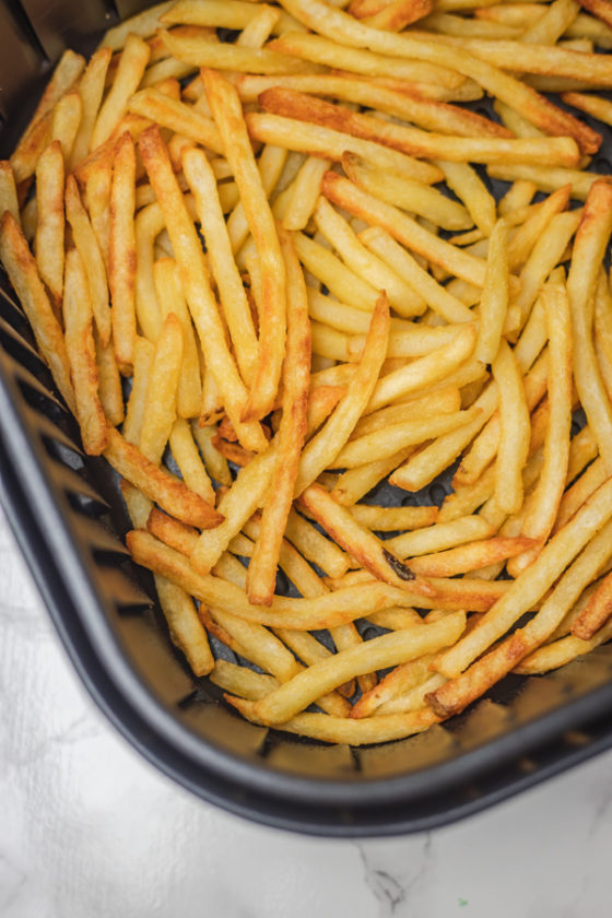 french fries in an air fryer basket.