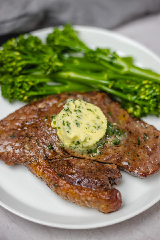 a plate of steak and broccoli stem.
