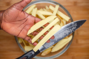 a hand holding sliced potatoes.
