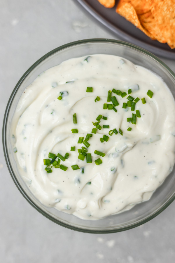 a bowl of cream garnished with chopped chives.
