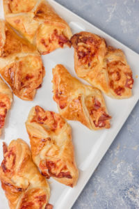 puff pastry turnovers on a white platter.