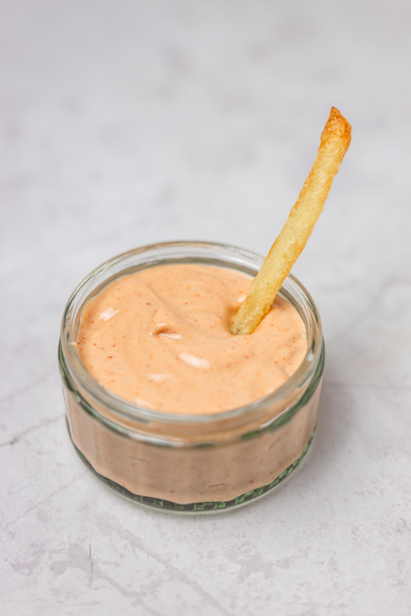 a chip dipped into a pot of creamy sauce.