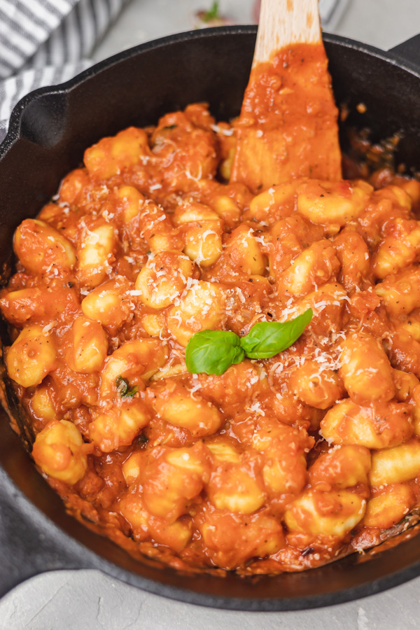 a skillet of gnocchi dumplings in red sauce.